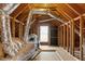 Spacious unfinished attic showing frame with ventilation system, wood flooring and a window at 8005 Sundance Cir, Durham, NC 27713