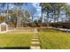Large backyard with stepping stones and a shed, in a well-maintained lawn, surrounded by mature trees at 8005 Sundance Cir, Durham, NC 27713