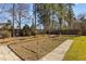 Spacious backyard garden bed with stone borders and pavers, surrounded by mature trees in a well-maintained lawn at 8005 Sundance Cir, Durham, NC 27713