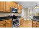 A well-equipped kitchen features stainless appliances, wooden cabinets, and granite countertops, with hardwood floors at 8005 Sundance Cir, Durham, NC 27713