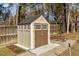 Backyard shed featuring a double door, well-maintained lawn, and lush greenery at 8005 Sundance Cir, Durham, NC 27713
