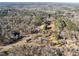 Aerial view of homes nestled in a wooded area with roads and open spaces at 113 Laurston Ct, Durham, NC 27712
