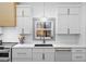 Modern kitchen with white shaker cabinets, quartz countertops, and a farmhouse sink at 113 Laurston Ct, Durham, NC 27712