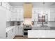 Modern kitchen with white cabinets, quartz countertops, and a light wood range hood at 113 Laurston Ct, Durham, NC 27712