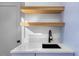 Modern wet bar with floating shelves and a quartz countertop at 113 Laurston Ct, Durham, NC 27712