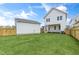 Spacious backyard with lush green grass, white siding house, and wooden fence at 129 Mossy Falls Way, Wendell, NC 27591