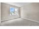 A bedroom with gray carpet and a window showing neighboring houses at 129 Mossy Falls Way, Wendell, NC 27591