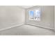 A bedroom with gray carpet and a window looking to the street at 129 Mossy Falls Way, Wendell, NC 27591
