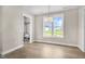 Sunlit dining area with a modern chandelier and large window with neighborhood views at 129 Mossy Falls Way, Wendell, NC 27591