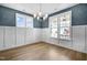 Bright dining room features wainscoting, wood floors, and chandelier lighting at 129 Mossy Falls Way, Wendell, NC 27591