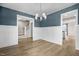 Formal dining room with blue accent wall, chandelier, and open staircase views at 129 Mossy Falls Way, Wendell, NC 27591