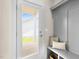 Entryway with storage bench and cushions adjacent to the exterior door with window pane at 129 Mossy Falls Way, Wendell, NC 27591