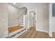 View of the light-filled entryway showcasing wood floors and staircase leading upstairs at 129 Mossy Falls Way, Wendell, NC 27591