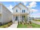 Inviting two-story home with a quaint front porch, featuring a light blue door and landscaped yard at 129 Mossy Falls Way, Wendell, NC 27591