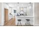Open kitchen with breakfast bar seating, stainless steel appliances, and bright lighting at 129 Mossy Falls Way, Wendell, NC 27591