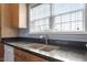 Well-lit kitchen featuring stainless steel faucet, granite countertops and double basin sink beneath a window at 133 John Winstead Rd, Louisburg, NC 27549