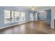 Open-concept living room with hardwood flooring, large windows, chandelier and glass front door at 133 John Winstead Rd, Louisburg, NC 27549