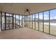 Enclosed sun room with walls of windows, neutral carpet and ceiling fan with wooded scenery in the background at 133 John Winstead Rd, Louisburg, NC 27549
