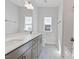 Bright bathroom with double vanity, large mirror, marble floors, and a large window at 137 Alderbranch Cir, Garner, NC 27529