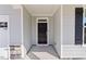 Inviting entrance featuring a black front door, stone accents, and light gray siding at 137 Alderbranch Cir, Garner, NC 27529
