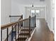 Bright upstairs hallway showcasing a hardwood floor, stairway and view into a bedroom at 137 Alderbranch Cir, Garner, NC 27529