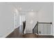 Bright hallway featuring dark wood floors, white walls and stairs with black metal railings at 137 Alderbranch Cir, Garner, NC 27529