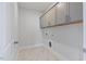 Well-lit laundry room featuring upper cabinets and marble-look tile flooring at 137 Alderbranch Cir, Garner, NC 27529