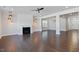 Open-concept living room with fireplace, elegant lighting, and hardwood floors at 137 Alderbranch Cir, Garner, NC 27529