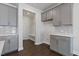 Mudroom with gray cabinets, white countertops, and herringbone backsplash at 137 Alderbranch Cir, Garner, NC 27529