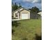 Tan house with white garage door and large grassy yard at 159 Bywood Dr, Roxboro, NC 27573