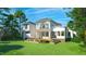 A luxurious backyard featuring a wooden deck, a manicured lawn, and lush landscaping at 180 Bur Oak Ct, Pittsboro, NC 27312
