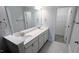 Bright bathroom featuring a double vanity with white cabinets and quartz countertop, plus a walk-in closet at 203 Broomgrove Way, Wake Forest, NC 27587