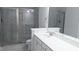 Modern bathroom features a glass-enclosed shower, white vanity with quartz countertop and neutral colored tiles at 203 Broomgrove Way, Wake Forest, NC 27587