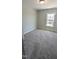 Bedroom with neutral carpet, walls, trim, and a view of the street at 203 Broomgrove Way, Wake Forest, NC 27587