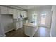 New kitchen with white cabinets, an island, stainless appliances, and hardwood floors at 203 Broomgrove Way, Wake Forest, NC 27587