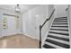 Bright foyer featuring hardwood floors and staircase with wooden railing and contrasting black treads at 2094 Harris Farm Ct, Burlington, NC 27215