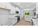 Well-lit kitchen offering stainless steel appliances, white cabinetry and quartz countertops at 2094 Harris Farm Ct, Burlington, NC 27215