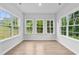 Bright sunroom with hardwood floors and large windows offering ample sunlight and outdoor views at 2094 Harris Farm Ct, Burlington, NC 27215