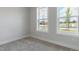 This bedroom features carpet flooring and windows that provide natural light and neighborhood views at 2117 Treelight Way, Wendell, NC 27591