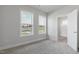 A bright bedroom featuring two windows, neutral carpet, and light grey walls at 2117 Treelight Way, Wendell, NC 27591