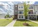 Modern townhome showcasing clean lines, mixed siding, a small balcony, and professionally landscaped front yard at 2117 Treelight Way, Wendell, NC 27591