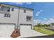 Modern three-story townhome featuring a two-car garage, balcony, and light grey siding at 2117 Treelight Way, Wendell, NC 27591