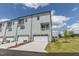 A modern three-story townhome with two-car garage, balcony, and manicured lawn at 2117 Treelight Way, Wendell, NC 27591