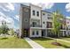 Striking townhome exterior with mixed material facade, contemporary lines, balcony, and manicured lawn at 2117 Treelight Way, Wendell, NC 27591