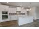 Bright kitchen with quartz island, shaker cabinets, and stainless appliances, perfect for modern living at 2117 Treelight Way, Wendell, NC 27591