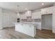 Newly constructed kitchen with white shaker cabinets, island, and stainless appliances at 2117 Treelight Way, Wendell, NC 27591
