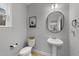 Well-appointed bathroom with pedestal sink and oval mirror at 263 Langdon Chase Way, Selma, NC 27576