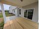 Covered back porch featuring wood decking, concrete patio, and sliding glass door access to the home at 46 Steppe Way, Garner, NC 27529