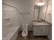 Bright bathroom featuring a tub with a shower and a vanity with granite countertops at 46 Steppe Way, Garner, NC 27529