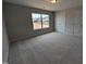 Spacious carpeted bedroom featuring a double door closet, and a view of the neighborhood at 46 Steppe Way, Garner, NC 27529